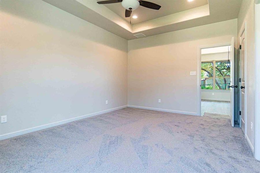 Unfurnished room with a tray ceiling, recessed lighting, light colored carpet, and ceiling fan