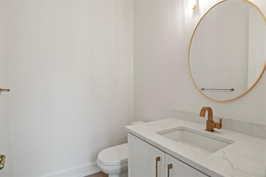 Half bathroom featuring vanity and toilet Half bathroom featuring vanity and toilet