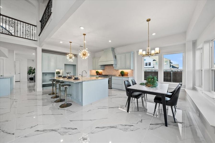 Kitchen featuring custom cabinetry, decorative pendant lighting, quartz counters, a kitchen breakfast bar, an island with sink, and recessed lighting Kitchen featuring custom cabinetry, decorative pendant lighting, quartz counters, a kitchen breakfast bar, an island with sink, and recessed lighting