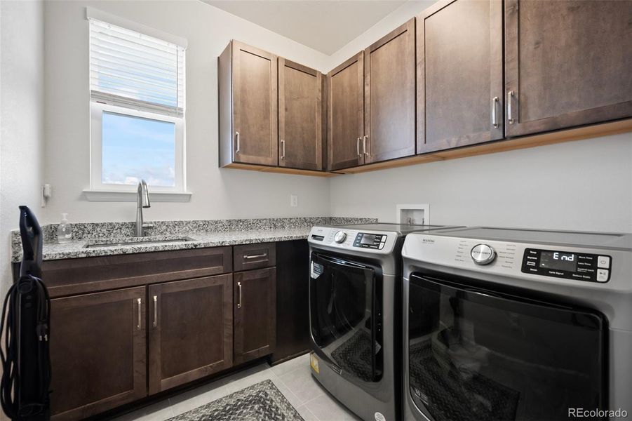 Tons of storage and sink in the laundry room.