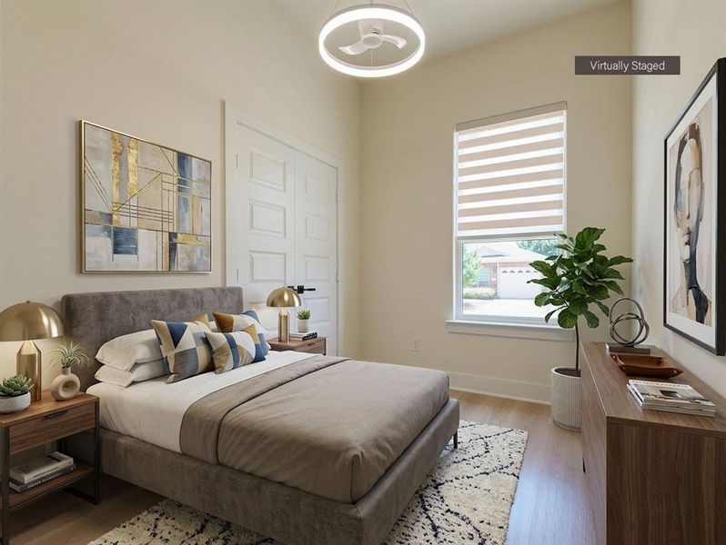 Spacious room featuring vaulted ceilings, wood-finish flooring, a contemporary ceiling light fixture, and a large window with blinds