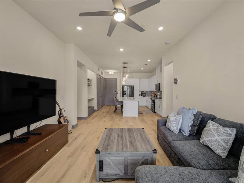 Living room featuring recessed lighting, light wood-style flooring, and a ceiling fan Living room featuring recessed lighting, light wood-style flooring, and a ceiling fan