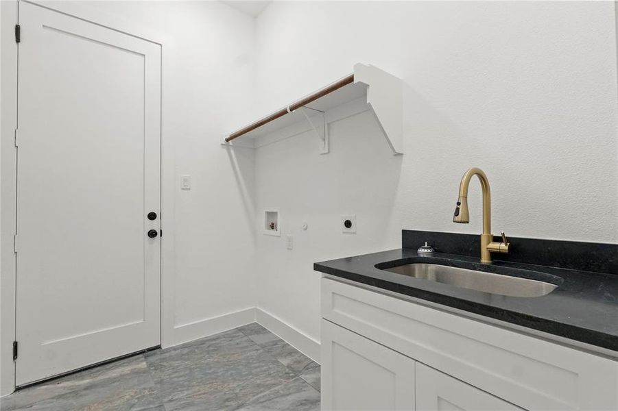 Washroom featuring electric dryer hookup, hookup for a washing machine, cabinet space, and light marble finish floors Washroom featuring electric dryer hookup, hookup for a washing machine, cabinet space, and light marble finish floors