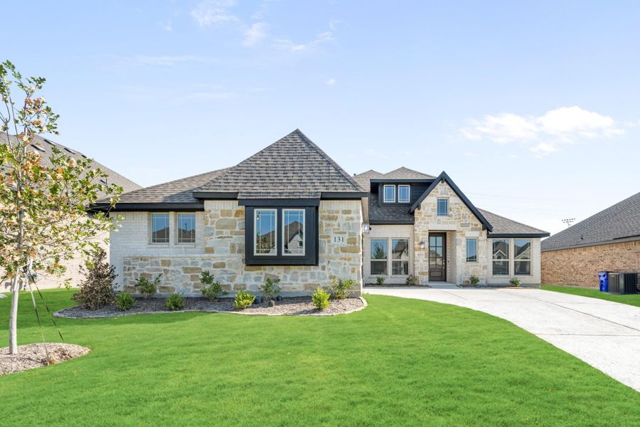 Single-story home with stone exterior, dark trim, pitched roof, and curved driveway with green lawn. Single-story home with stone exterior, dark trim, pitched roof, and curved driveway with green lawn.