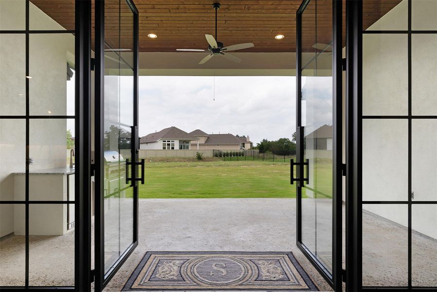 These open-air French doors connect interior living to a spacious outdoor entertaining area.