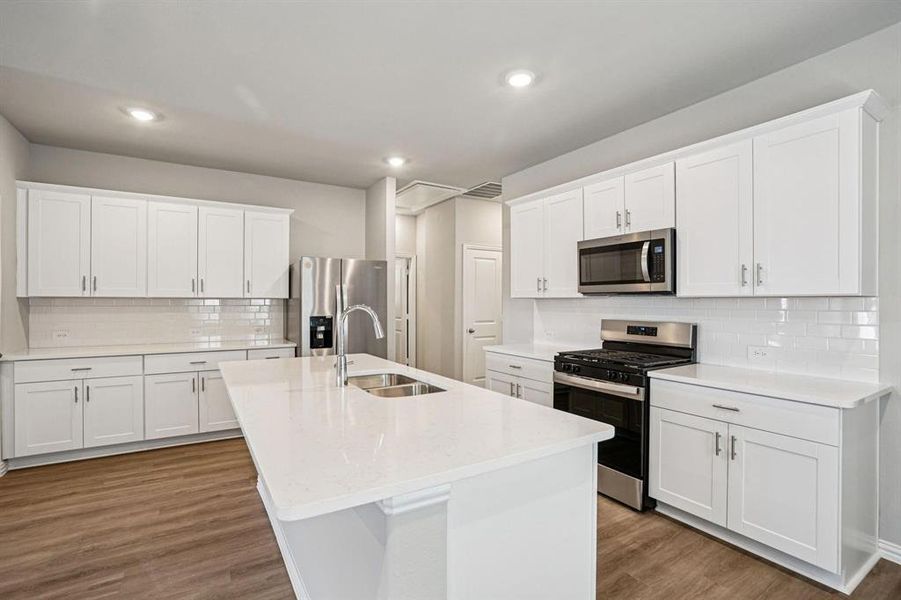 Kitchen featuring stainless steel appliances, white cabinetry, tasteful backsplash, dark wood-type flooring, and recessed lighting