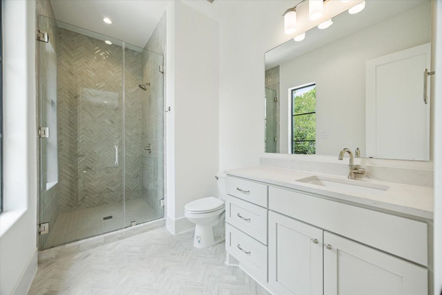 En-suite bath - has enclosed walk-in shower and quartz countertop.