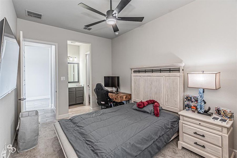 Bedroom featuring a ceiling fan, light-toned walls, and carpet flooring