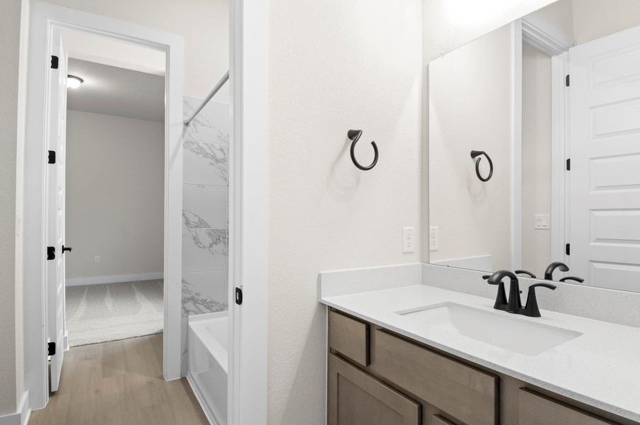 Full bathroom featuring vanity, shower / bath combo with shower curtain, and light wood-type flooring