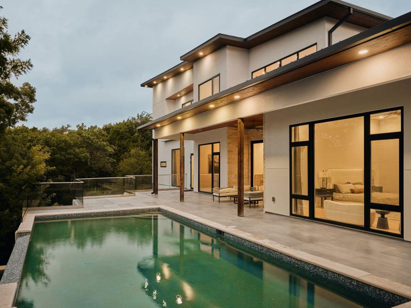 An impressive exterior features a shimmering pool alongside a private patio, perfect for evening relaxation. An impressive exterior features a shimmering pool alongside a private patio, perfect for evening relaxation.