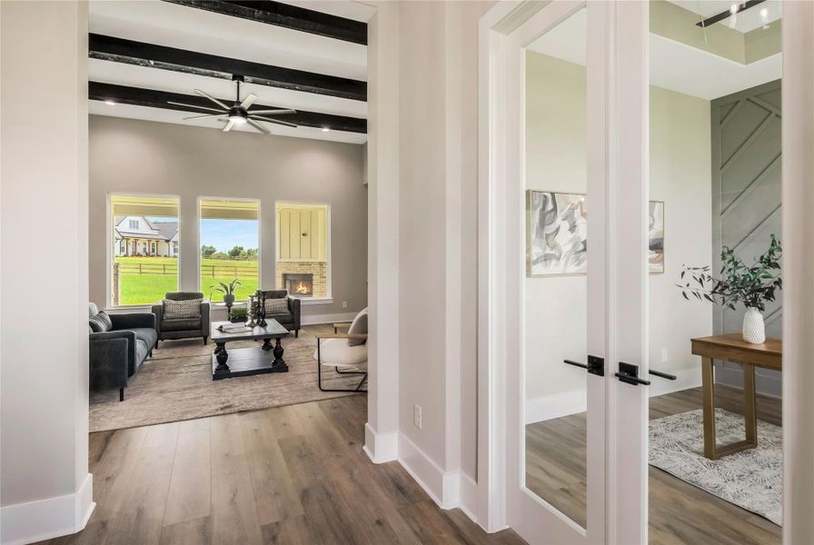 This photo showcases a bright, open living area with modern design elements, study is to the right with glass double doors. This photo showcases a bright, open living area with modern design elements, study is to the right with glass double doors.