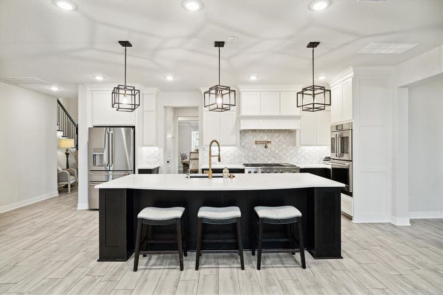 Custom built soft close cabinetry featuring pot & pan drawers at the cooktop with a utensil pull out tray, under cabinet lighting and a large island with gorgeous quartz counters