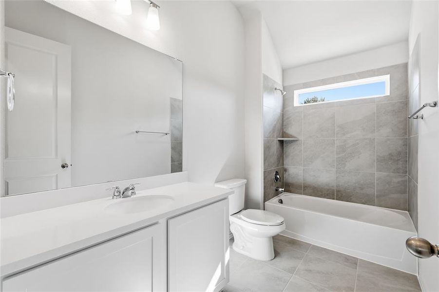 Full bathroom with bathtub / shower combination, vanity, and light tile patterned floors