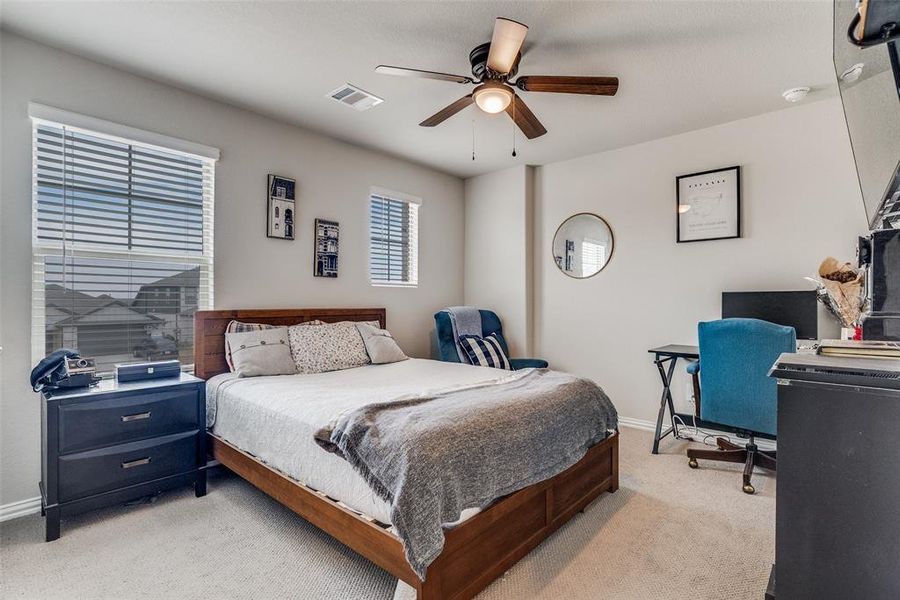 Bedroom with light carpet, ceiling fan, and a desk Bedroom with light carpet, ceiling fan, and a desk