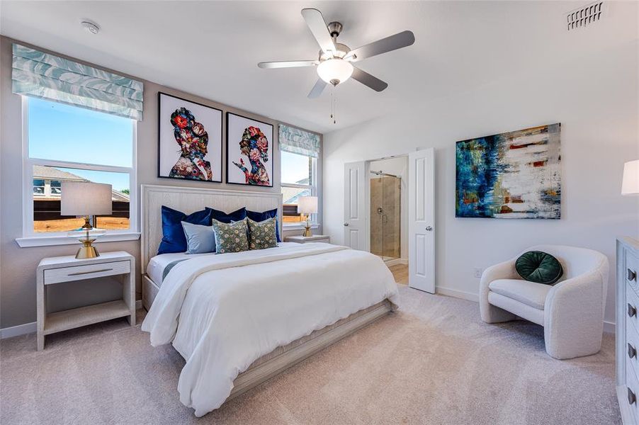 Bedroom featuring ceiling fan, connected bathroom, and light carpet