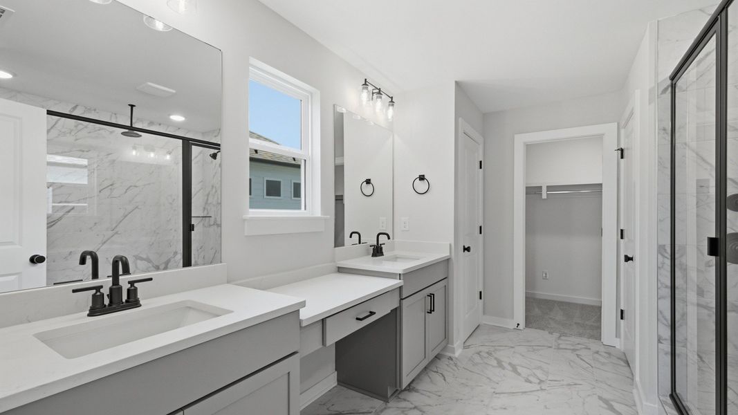 En-suite primary bathroom with dual vanity, tile flooring, and natural light En-suite primary bathroom with dual vanity, tile flooring, and natural light