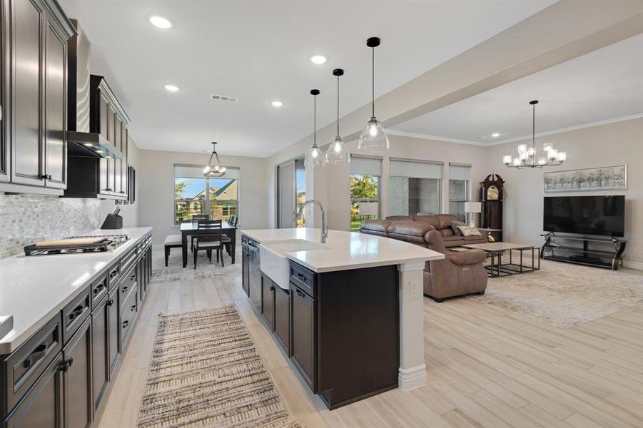 The kitchen is large and equipped with upscale appliances, contemporary vent hood, and gleaming quartz countertops.