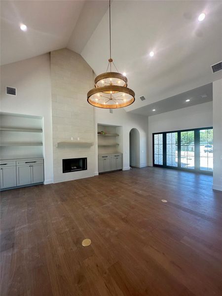 A soaring vaulted ceiling and a handsome stone fireplace anchor this airy open space.