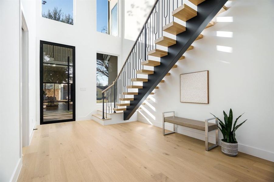 Entryway featuring a high ceiling and light hardwood / wood-style flooring