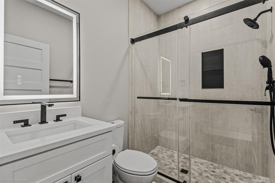 Downstairs bathroom with shower, and electric mirror.