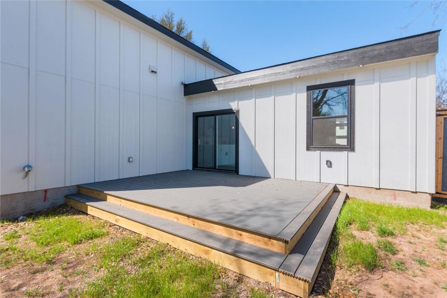 Back of property featuring board and batten siding and a deck