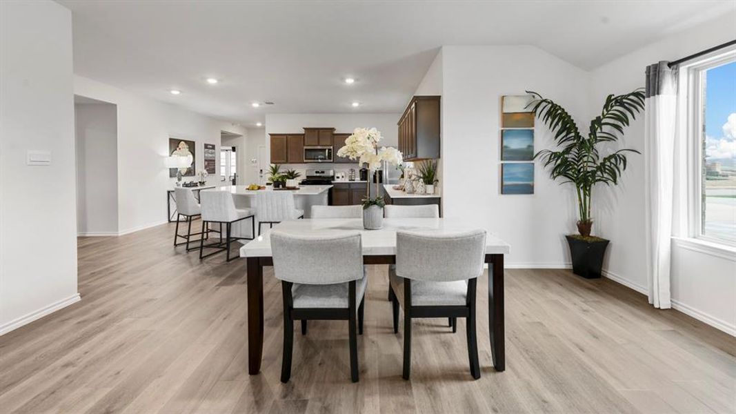Open-concept living area featuring wood-finish flooring, recessed lighting, and white walls Open-concept living area featuring wood-finish flooring, recessed lighting, and white walls