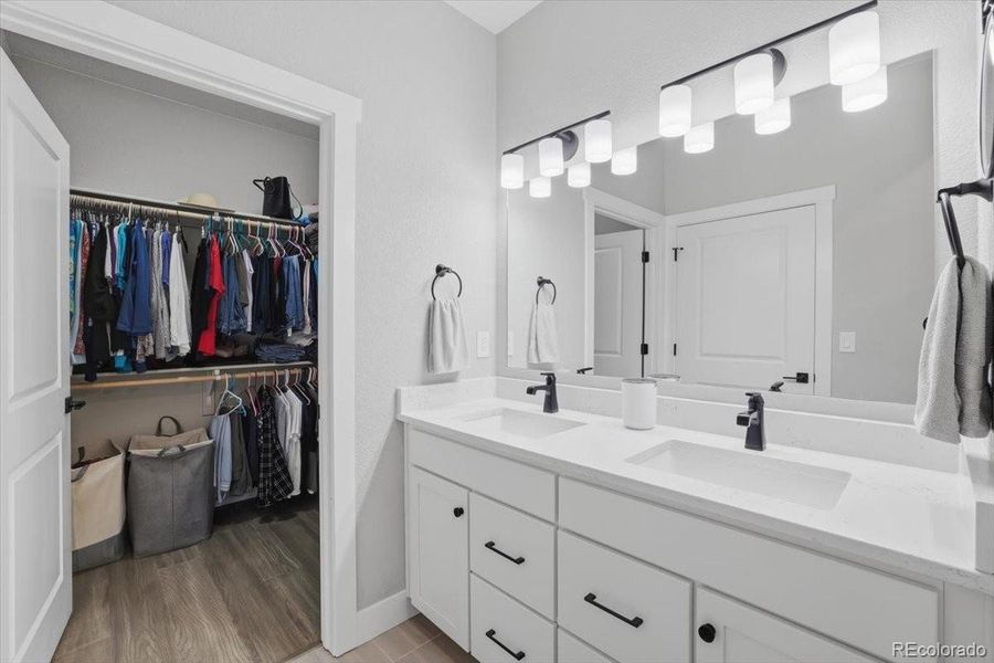 With dual vanities and plenty of storage, this primary bathroom is as functional as it is beautiful. There is a walk-in closet to the left.