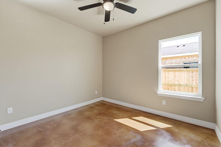 Spare room featuring finished concrete flooring and a ceiling fan
