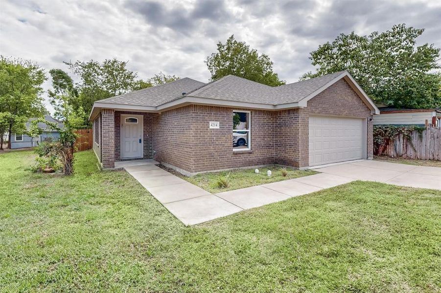 Single story home with a garage and a front lawn