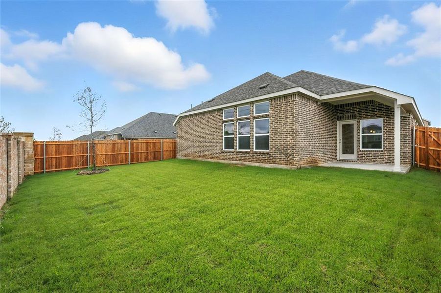 Rear view of house featuring a fenced backyard, brick siding, a patio, and roof with shingles Rear view of house featuring a fenced backyard, brick siding, a patio, and roof with shingles