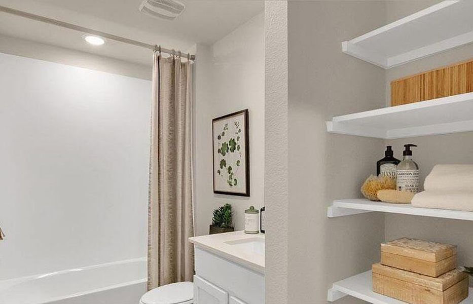 Full bathroom featuring toilet, shower / tub combo with curtain, vanity, and recessed lighting Full bathroom featuring toilet, shower / tub combo with curtain, vanity, and recessed lighting