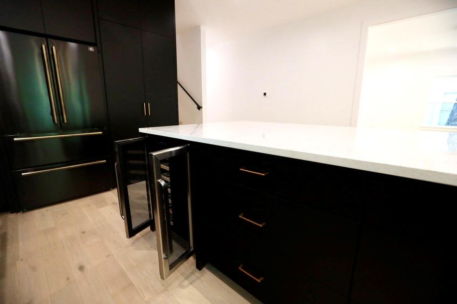 Kitchen with dark cabinets, high quality fridge, and modern cabinets