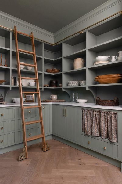 Walk-in Pantry has Custom built-in shelving with crown molding, brass hardware, and a rolling ladder, microwave opening for built-in microwave. Flooring is white oak and is in a herringbone pattern, Pantry opens up to the kitchen nook. Walk-in Pantry has Custom built-in shelving with crown molding, brass hardware, and a rolling ladder, microwave opening for built-in microwave. Flooring is white oak and is in a herringbone pattern, Pantry opens up to the kitchen nook.