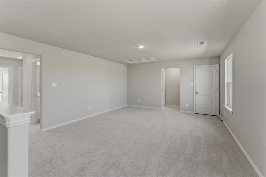 Unfurnished bedroom with multiple windows and light carpet