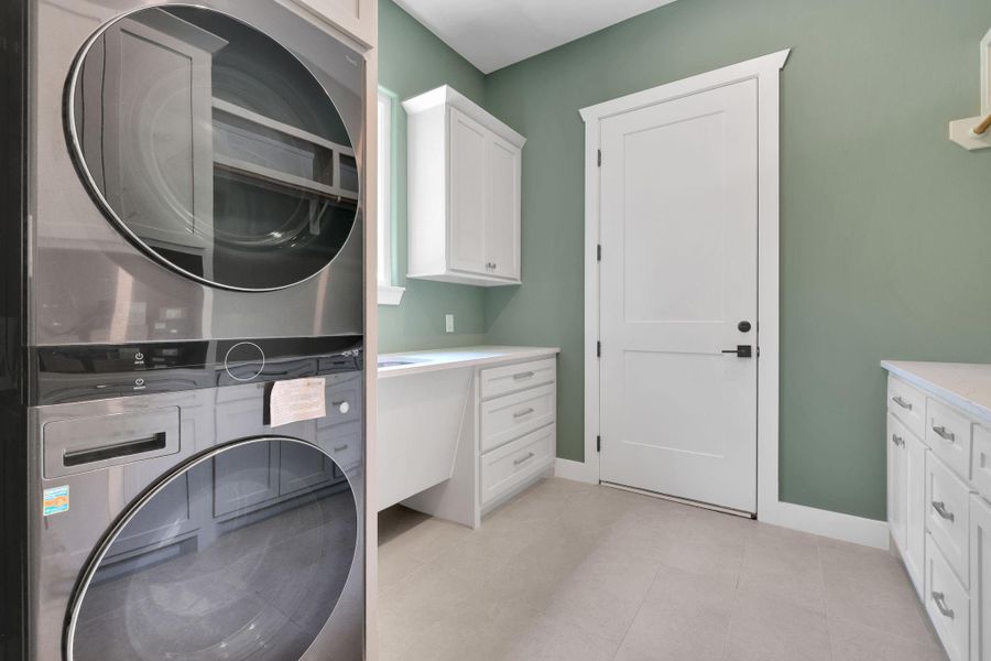 Spacious laundry room with built-in storage, folding space, and a full size LG Laundry Tower