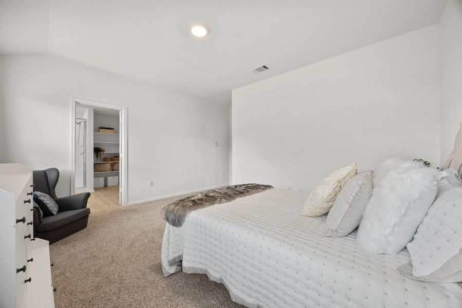 Bedroom featuring light colored carpet and a spacious closet