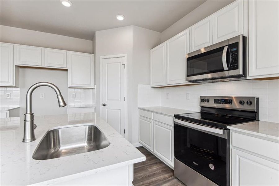 A kitchen with white cabinets.