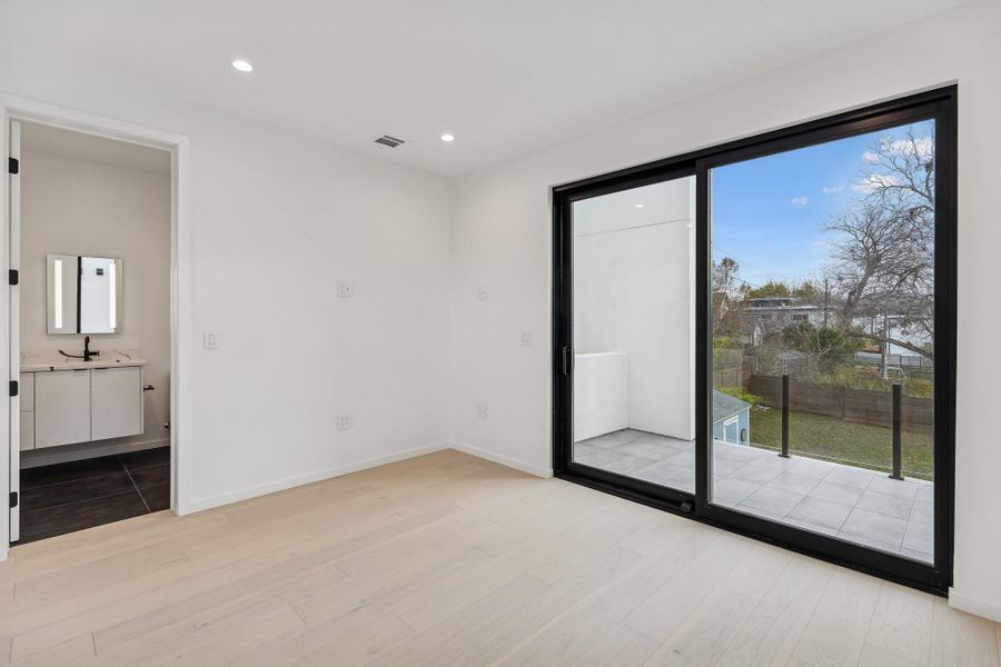 Unfurnished bedroom with light wood-style flooring, access to exterior, and recessed lighting