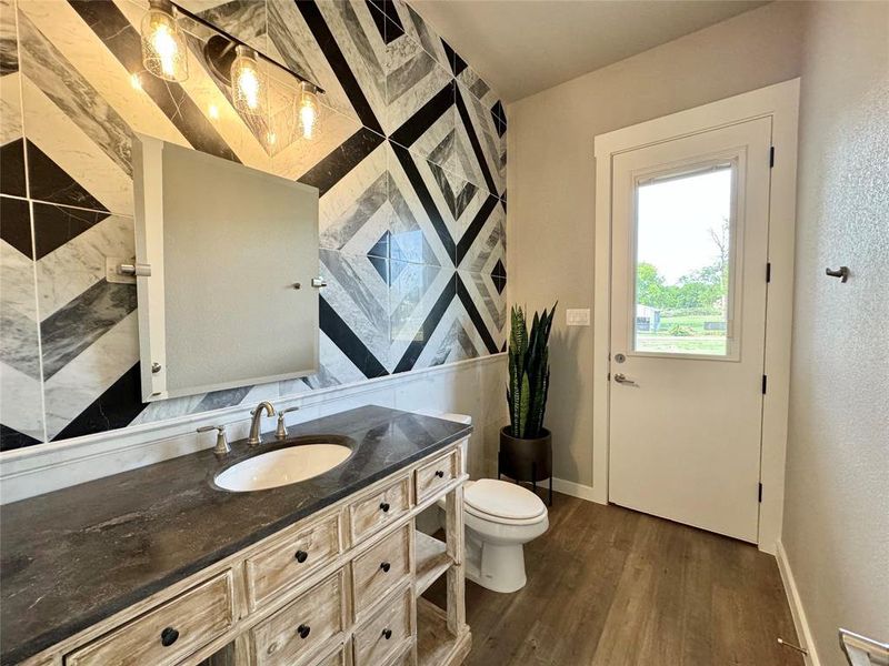 Bathroom featuring vanity, toilet, and wood-type flooring