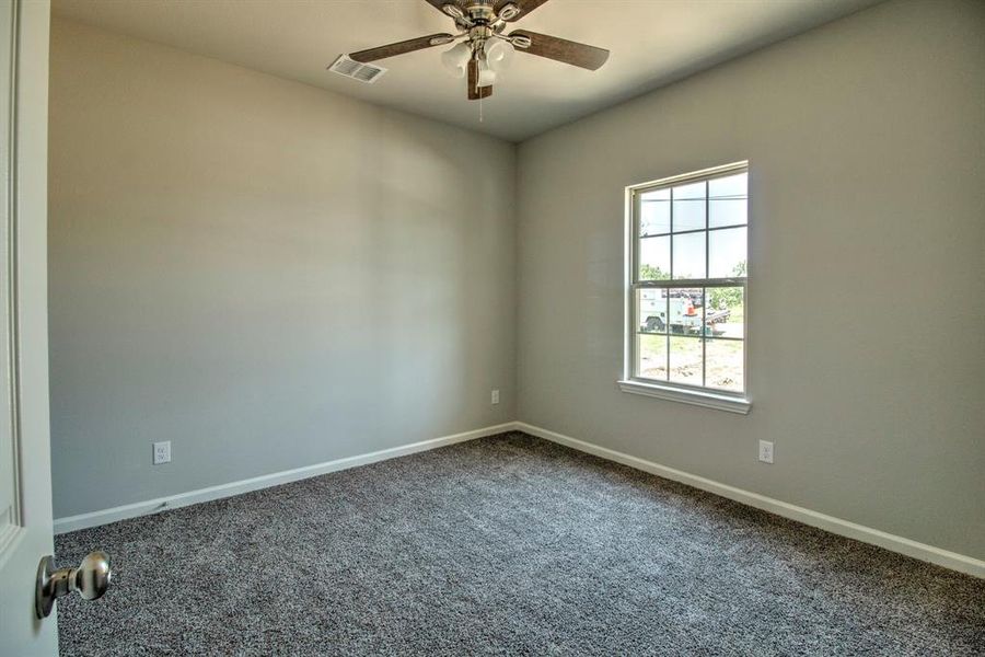 Carpeted spare room featuring ceiling fan