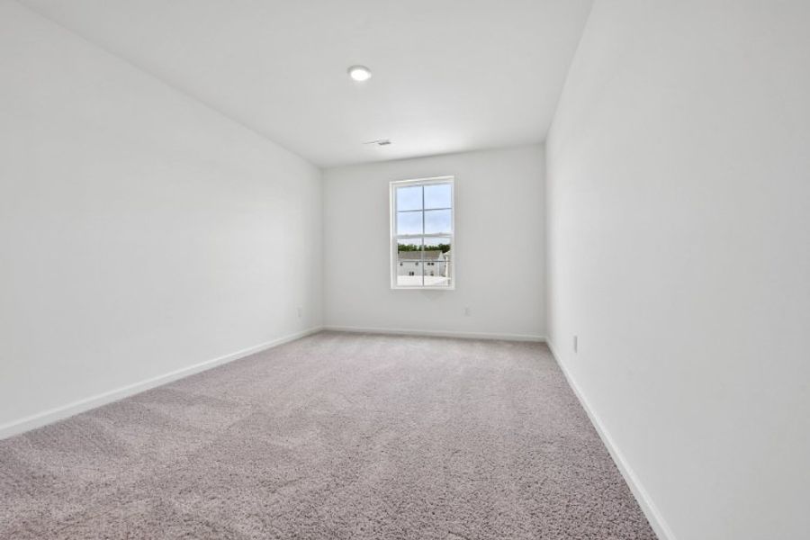 A room with a window and carpet.