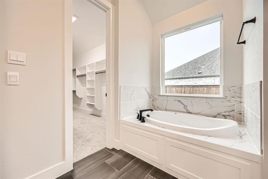 Bathroom with a washtub and vaulted ceiling