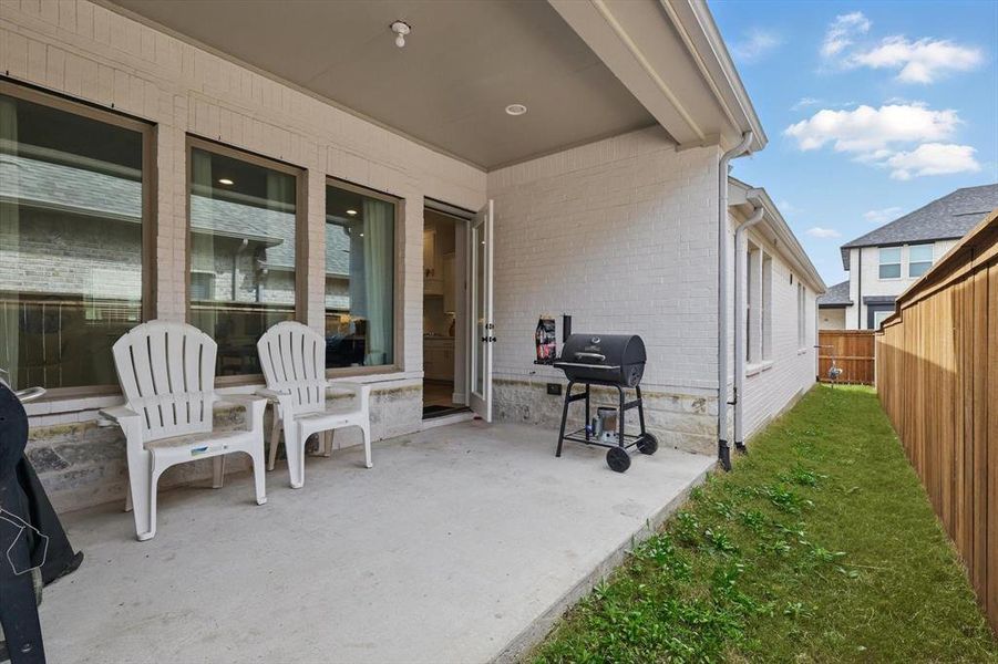 View of patio with a grill and fence