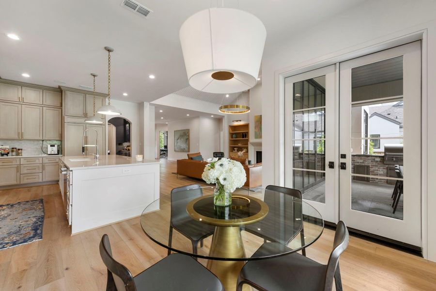 Open breakfast area with patio doors that open to the covered outdoor kitchen and patio, creating an effortless connection for indoor-outdoor living!