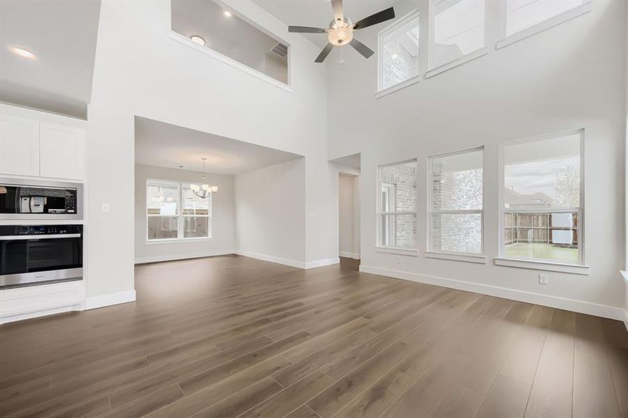 Spacious room with high ceilings, multiple windows, and wood-finish flooring