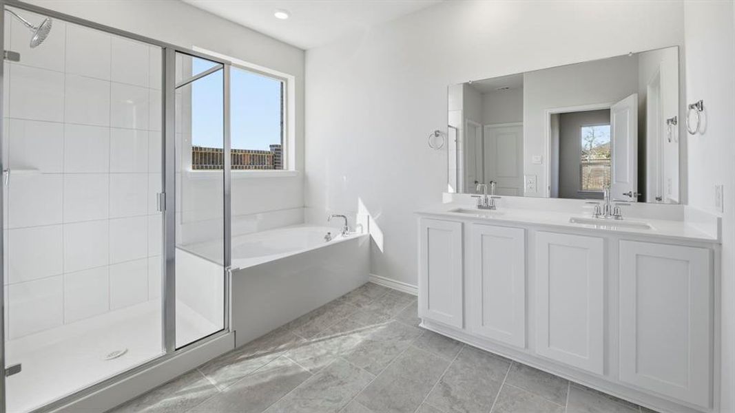 Spacious bathroom featuring a dual vanity with white cabinetry and an expansive mirror
