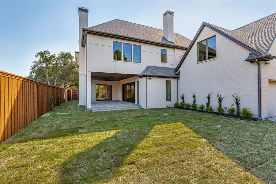 Back of house featuring a chimney, a patio, brick siding, and a fenced backyard Back of house featuring a chimney, a patio, brick siding, and a fenced backyard