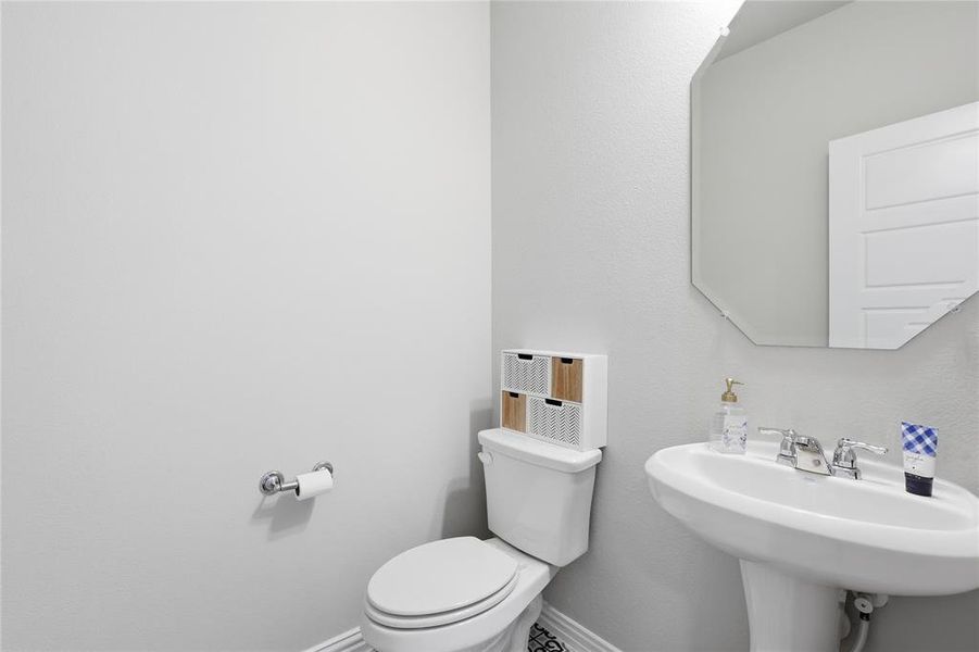 Pedestal sink with chrome faucet, octagonal wall mirror, and panel door