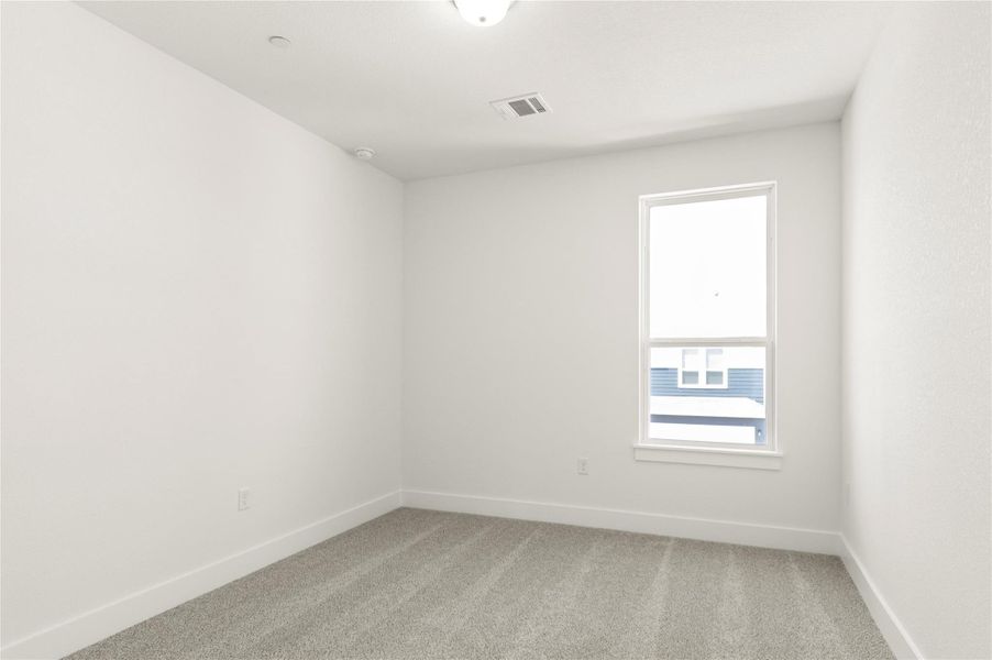 Empty room featuring light carpet and baseboards