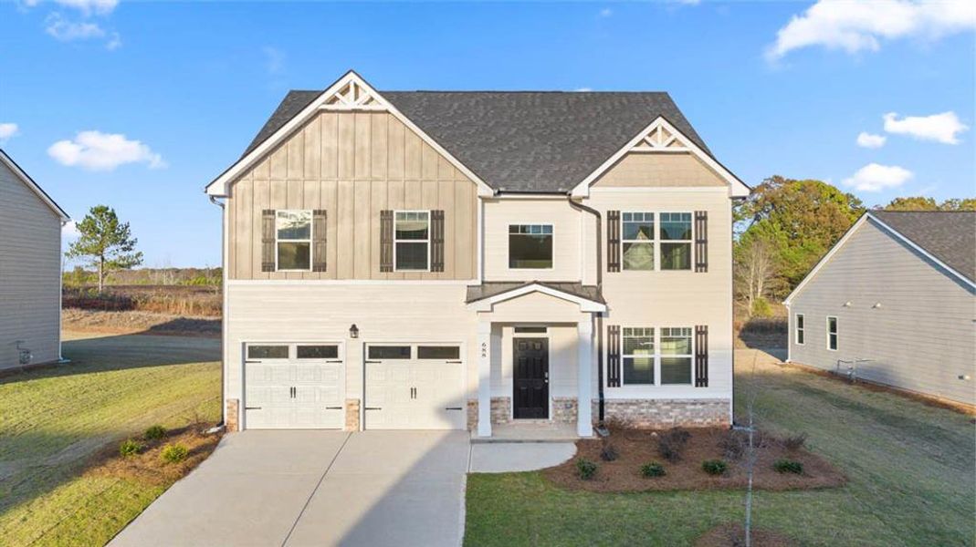 View of front of property with a garage and a front lawn